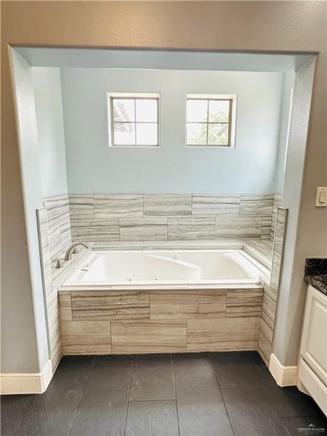 Full bath featuring a jetted tub, tile patterned floors, and vanity | Image 11