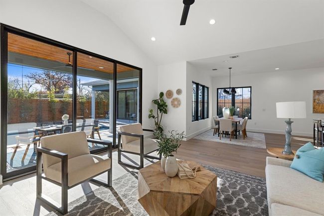 Living area featuring recessed lighting, wood finished floors, lofted ceiling, baseboards, and a chandelier | Image 24