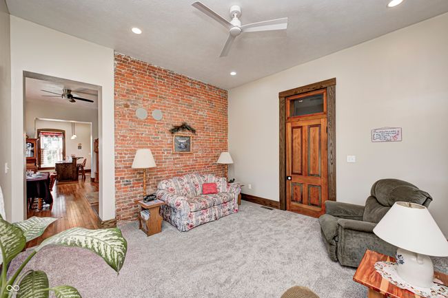living room with brick wall, recessed lighting, carpet flooring, and a ceiling fan | Image 12