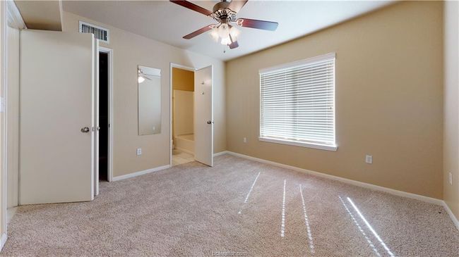 Unfurnished bedroom with visible vents, ensuite bath, light carpet, and baseboards | Image 6