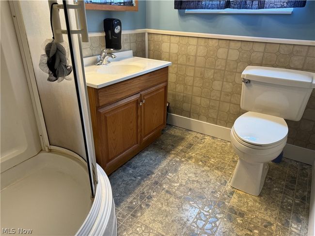 Bathroom featuring tile walls, backsplash, tile floors, toilet, and vanity | Image 25