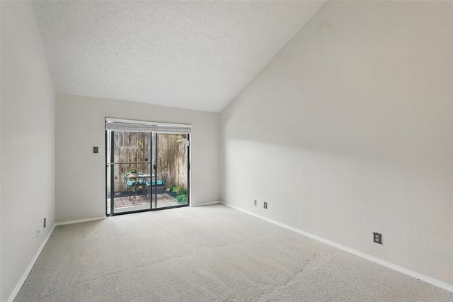 Empty room featuring new carpet, vaulted ceilings | Image 10