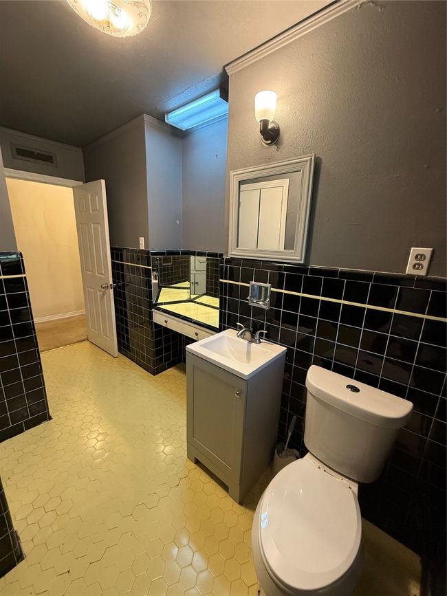 Bathroom featuring vanity, wainscoting, tile patterned floors, and tile walls | Image 10