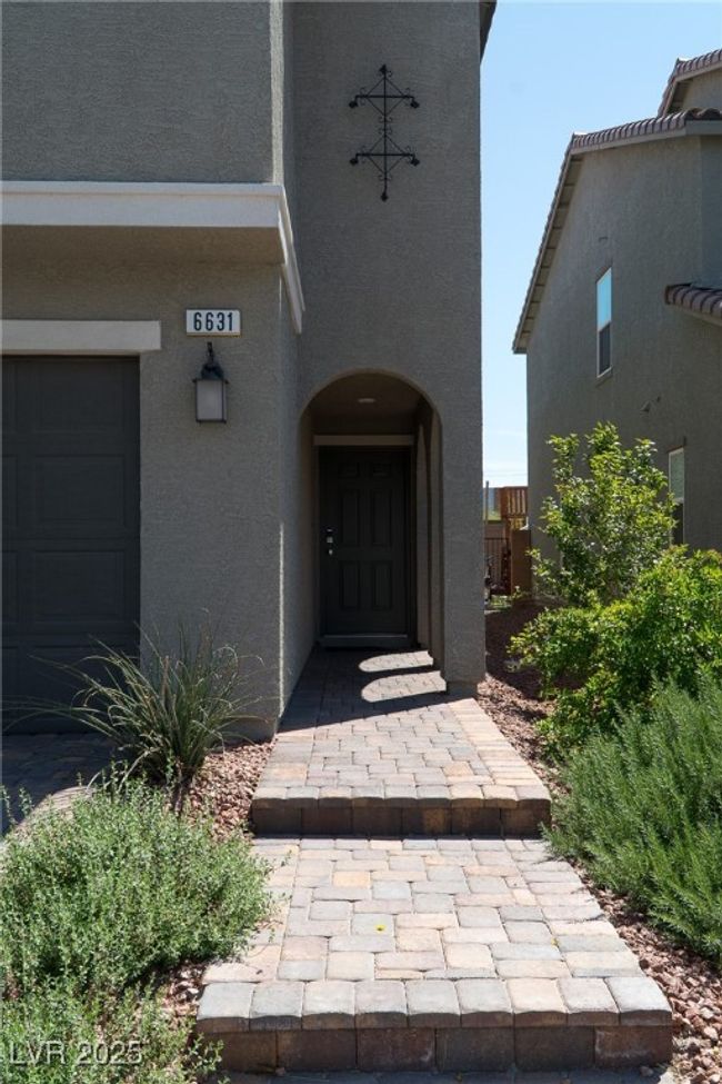 Property entrance with a garage and stucco siding | Image 4