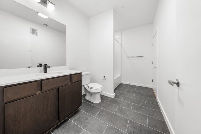 Full bathroom featuring visible vents, toilet, tile patterned flooring, tub / shower combination, and vanity | Image 8