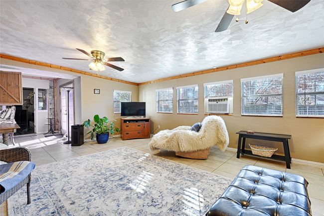 Second Living room or sunroom with cooling unit, ceiling fan, light tile patterned floors, and ornamental molding | Image 15