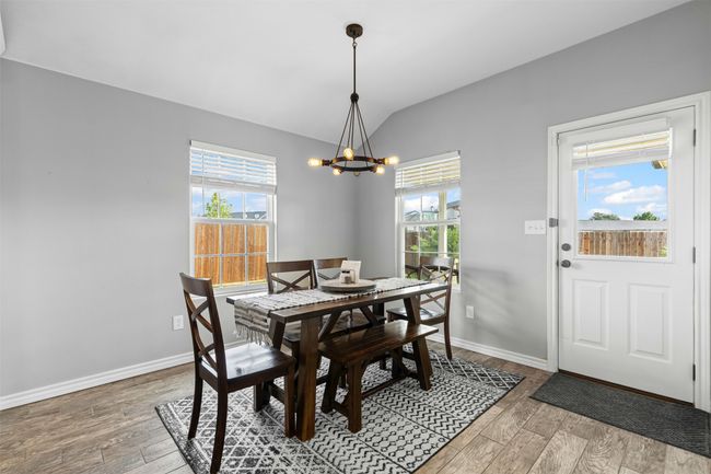 Dining area with lofted ceiling, a chandelier, plenty of natural light, light wood finished floors, and baseboards | Image 14