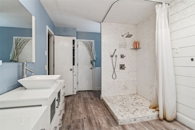 Full bath with wood finished floors, a tile shower, and vanity | Image 15