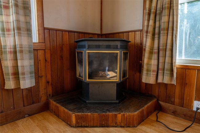 Detailed view of a wood stove, wainscoting, wooden walls, and wood finished floors | Image 8