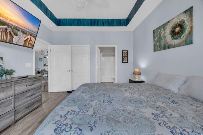 Bedroom featuring a towering ceiling, ensuite bathroom, wood finished floors, and a ceiling fan | Image 19