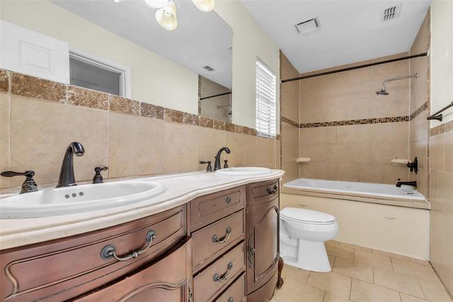 This primary bathroom includes a bathroom with double sinks and a tub and shower combo. | Image 20
