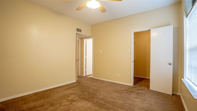 Unfurnished bedroom with carpet flooring, a ceiling fan, and baseboards | Image 14