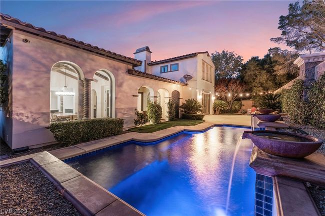 Beautiful lighting at night of pool, fountains, loggia on the right and lighting over patio space. | Image 17