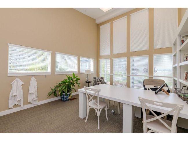Home office featuring a high ceiling, carpet floors, and baseboards | Image 25