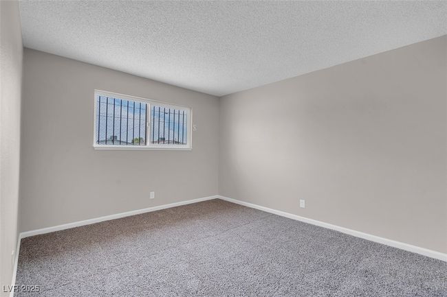 Empty room featuring carpet floors, a textured ceiling, and baseboards | Image 19