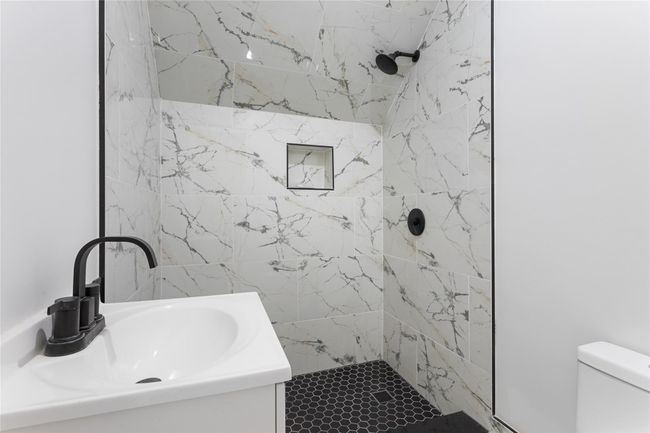 Bathroom with a shower stall, a sink, and toilet | Image 10
