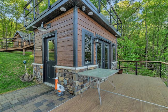 Fully equipped fish house featuring a convenient serving line, built-in speakers, and a TV—perfect for entertaining and enjoying lakeside gatherings. | Image 24