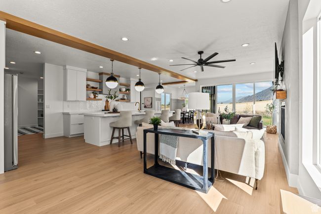 Living room with beam ceiling, light wood-style flooring, recessed lighting, and a ceiling fan | Image 12
