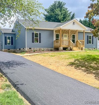 Single story home with a porch and a front yard. This picture is of same floor plan built on a different lot. This house does NOT come with asphalt driveway. | Image 1