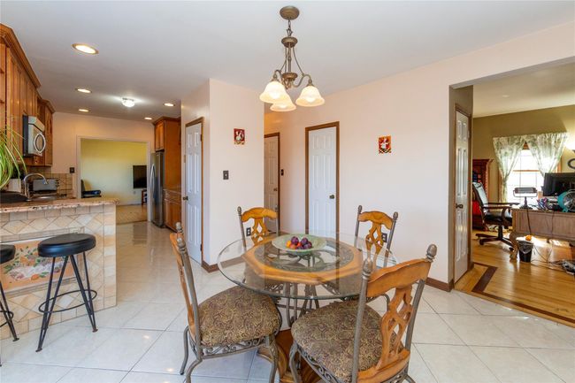 Dining area featuring light tile patterned floors, baseboards, recessed lighting, and a chandelier | Image 25