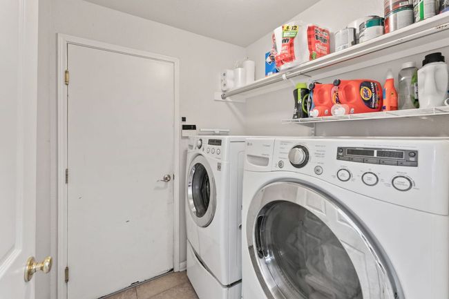 Laundry area with separate washer and dryer and light tile patterned floors | Image 12