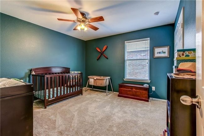 Carpeted bedroom with a crib and ceiling fan | Image 12