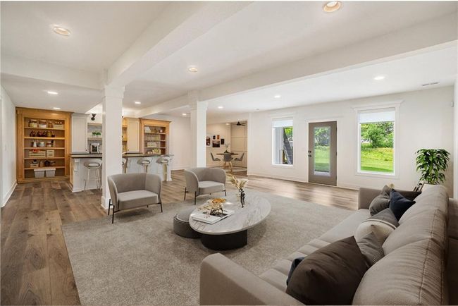 Living area featuring decorative columns, recessed lighting, wood finished floors, bar area, and baseboards | Image 56