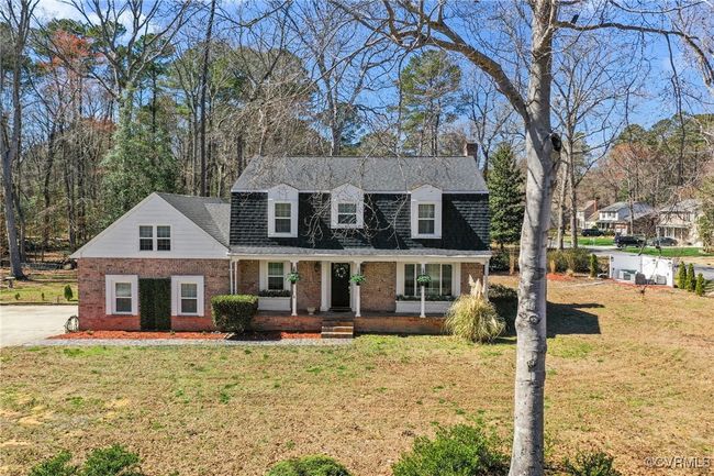 View of front facade with a front lawn, covered porch, brick siding, and a shingled roof | Image 49