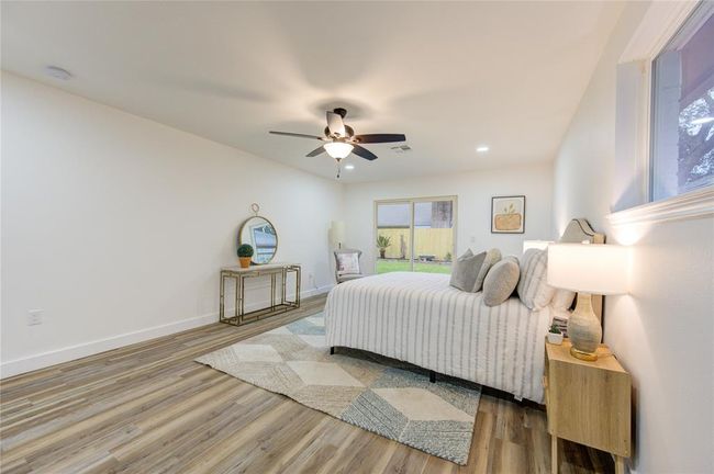 The primary bedroom features luxury vinyl flooring and large windows that bring in plenty of natural light. The freshly painted walls and updated trim provide a clean, inviting feel. This spacious room offers ample space for furniture and a relaxing retreat. | Image 16
