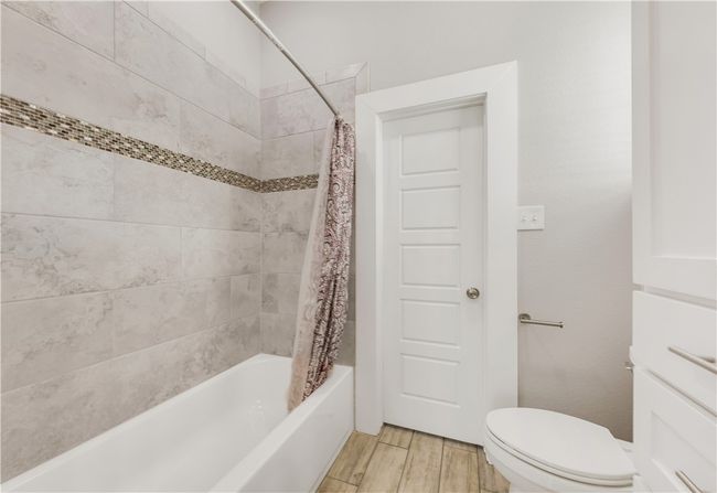 Full bathroom featuring shower / bath combo with shower curtain, toilet, and wood finished floors | Image 20