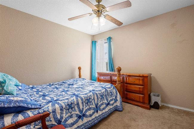Bedroom with a ceiling fan, a textured wall, carpet, and baseboards | Image 21