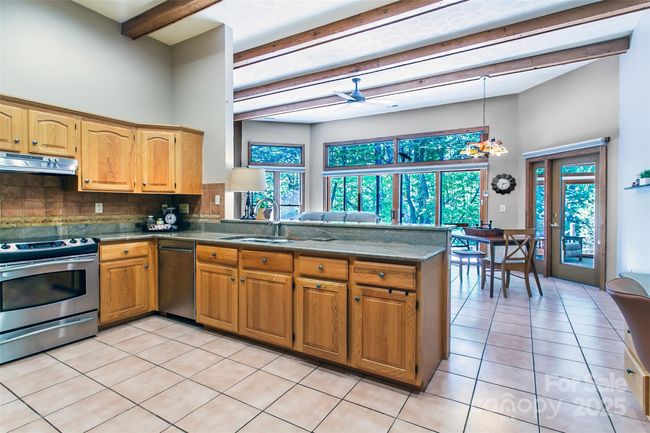 Enjoy company as you work in the kitchen and they use the den | Image 8