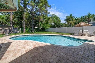 Large pool surrounded by brick pavers | Image 3