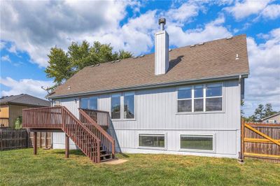 Rear view of house featuring a wooden deck and a lawn | Image 3