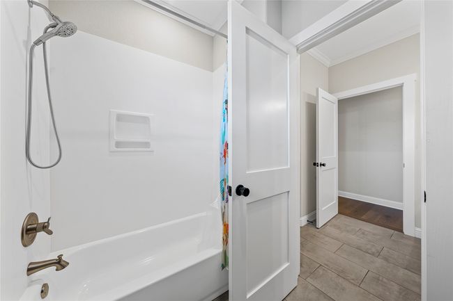 Full bathroom featuring shower / bath combination with curtain, baseboards, and wood finished floors | Image 21