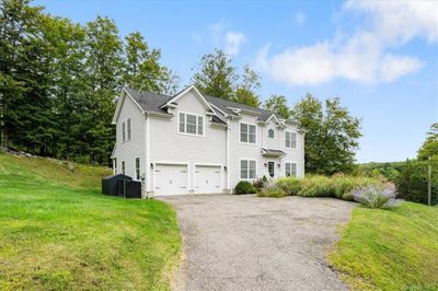 Front facade with a garage, a front lawn, and central air condition unit | Image 2