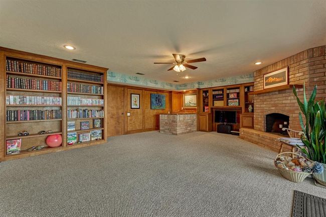 This angle reveals built-in shelving, a convenient wet bar, and a corner fireplace that adds warmth and character to the space. | Image 28