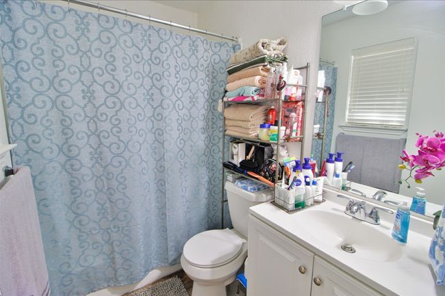 Full bath with toilet, vanity, and a shower with shower curtain | Image 15
