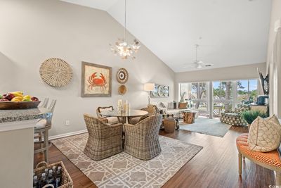 Interior space with wood-type flooring, ceiling fan with notable chandelier, and high vaulted ceiling | Image 3