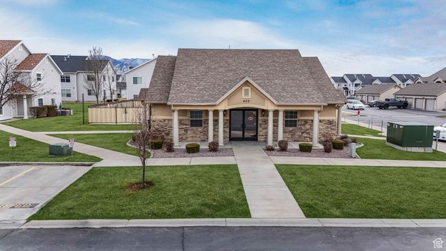 View of front of property with stone siding, a front lawn, roof with shingles, a residential view, and stucco siding | Image 20