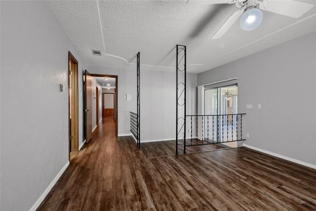 Unfurnished room featuring baseboards, a textured ceiling, a ceiling fan, visible vents, and wood finished floors | Image 28