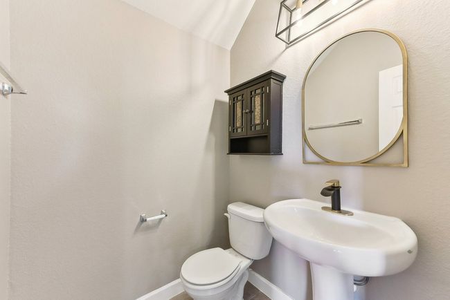 Bathroom featuring baseboards, toilet, and a sink | Image 12