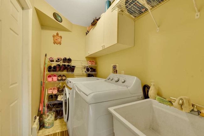 Laundry area with cabinet space, separate washer and dryer, and a baseboard radiator | Image 14