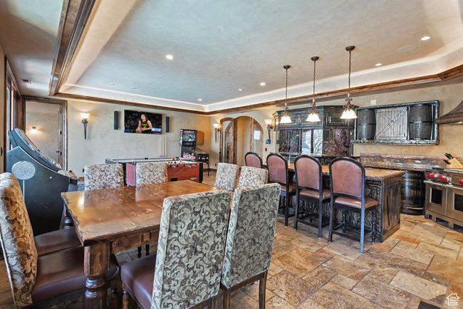 Dining room featuring recessed lighting, a raised ceiling, arched walkways, and stone tile floors | Image 48
