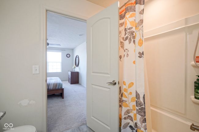 bathroom with a textured ceiling and a shower with curtain | Image 32