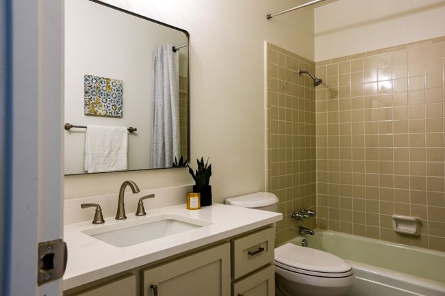 Bathroom featuring washtub / shower combination and custom vanity. | Image 25