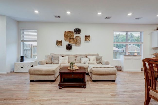 The living room is bright and spacious. With beautiful flooring and neutral colors, this home is move in ready. | Image 9