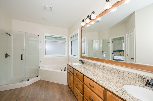 Full bath with wood finished floors, a shower stall, a garden tub, and a sink | Image 19