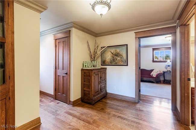 Corridor with baseboards, crown molding, and wood finished floors | Image 33