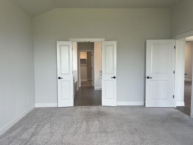 Unfurnished bedroom featuring baseboards, lofted ceiling, and carpet | Image 16